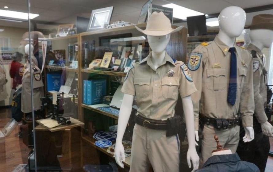 Photo inside of the new Sheriff Museum. Foreground contains mannequins showing the uniforms worn under Sheriff Joe Corley. 